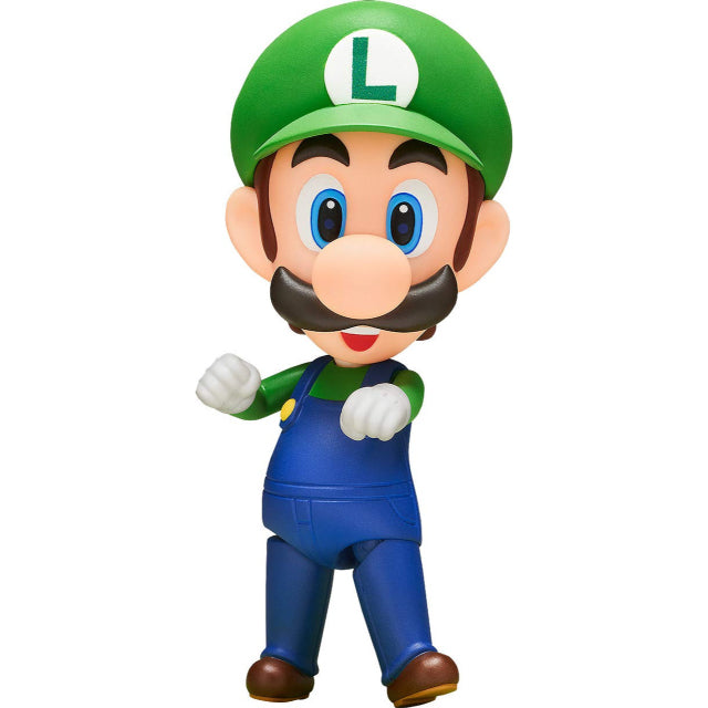 A collectible Luigi figure from the Good Smile Company's Nendoroid series. This chibi-style figure showcases Luigi in his classic green cap with an 'L' emblem, blue overalls, and white gloves. He has an expressive, cheerful face with large blue eyes and a thick mustache. The figure is posed dynamically, with arms bent and fists clenched as if ready for action. The sculpt and paintwork capture Luigi’s signature look from the Super Mario series in an adorable, articulated design.